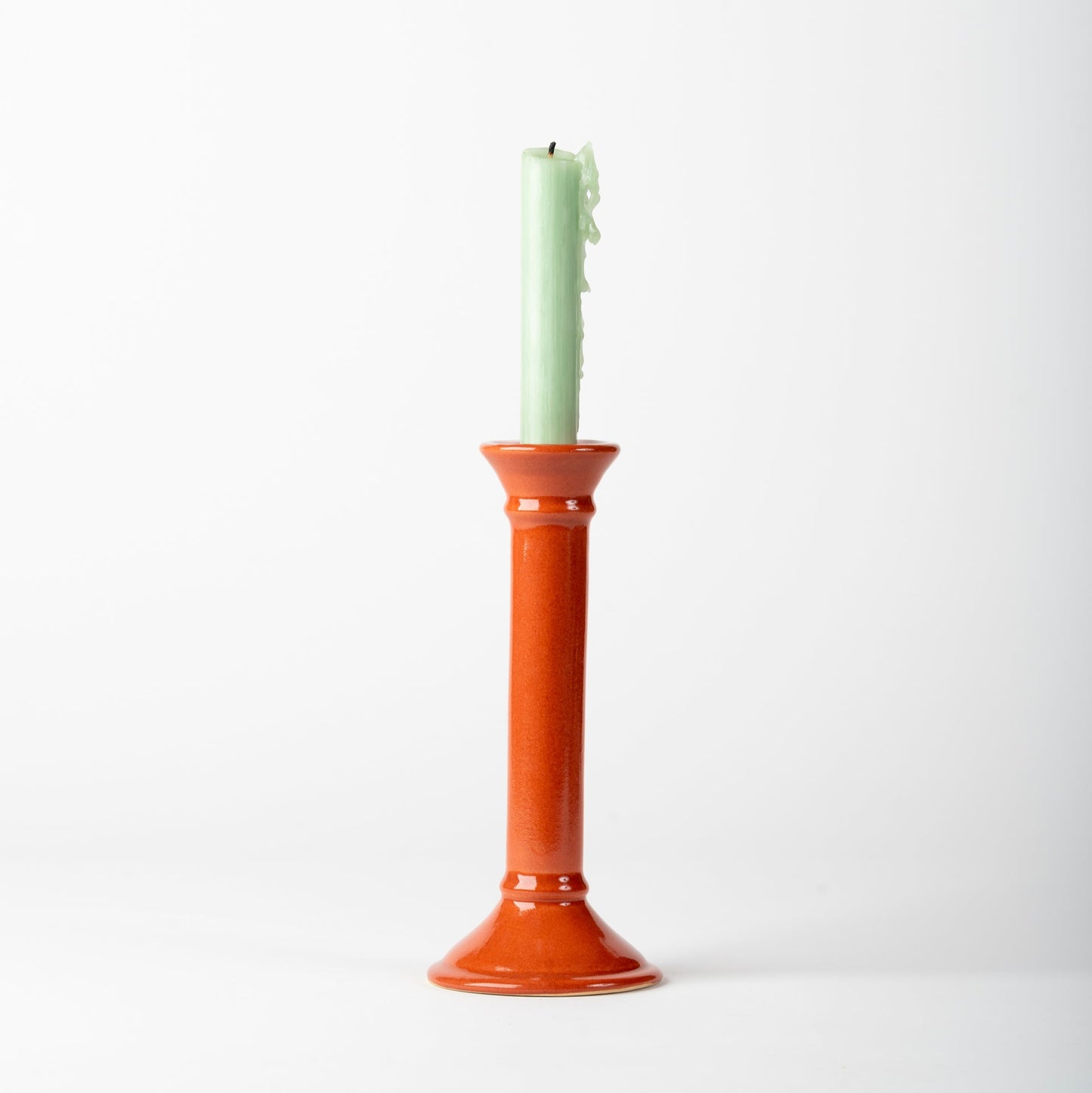 Candlestick with a green candle on a white background