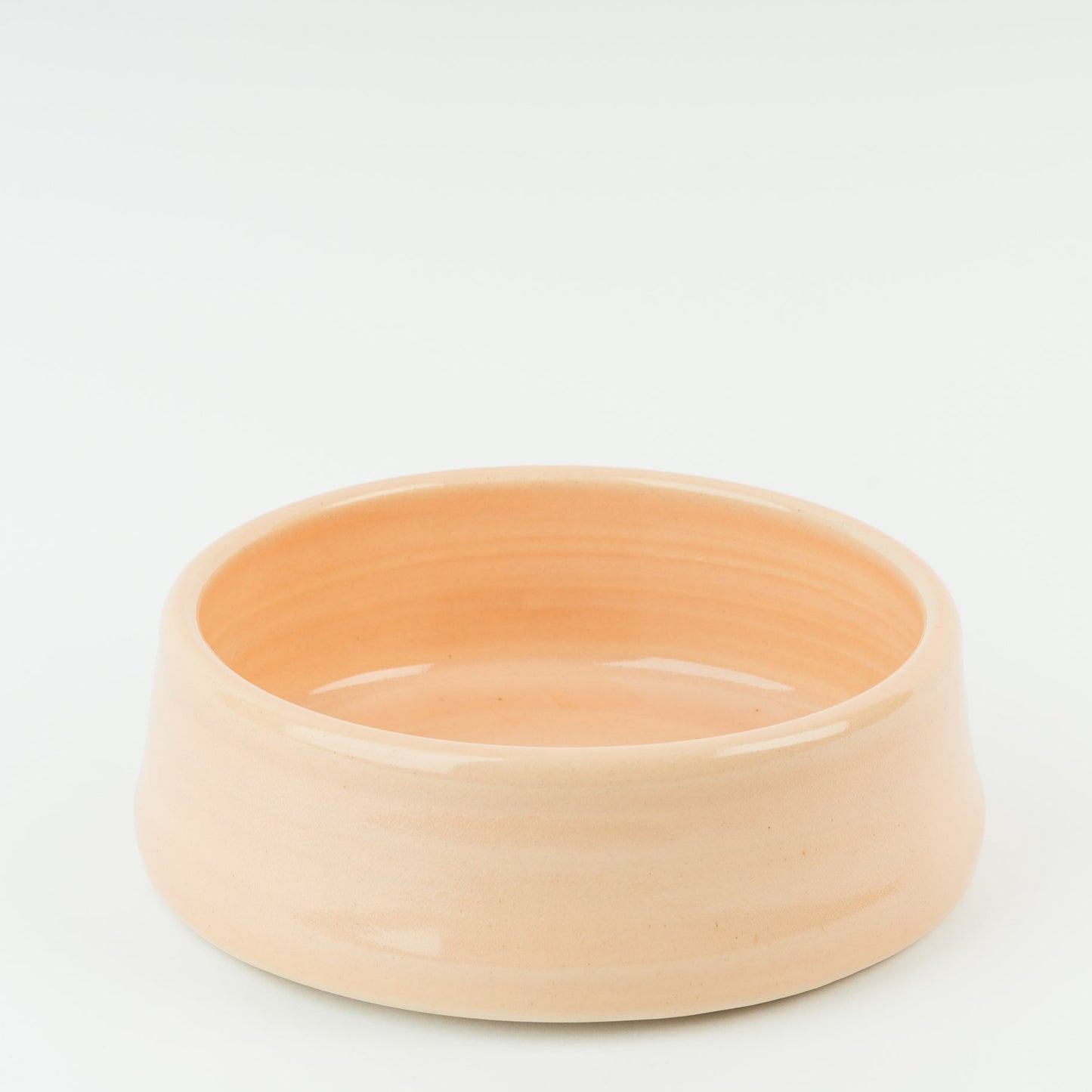 Pale pink ceramic pet bowl on a light grey background