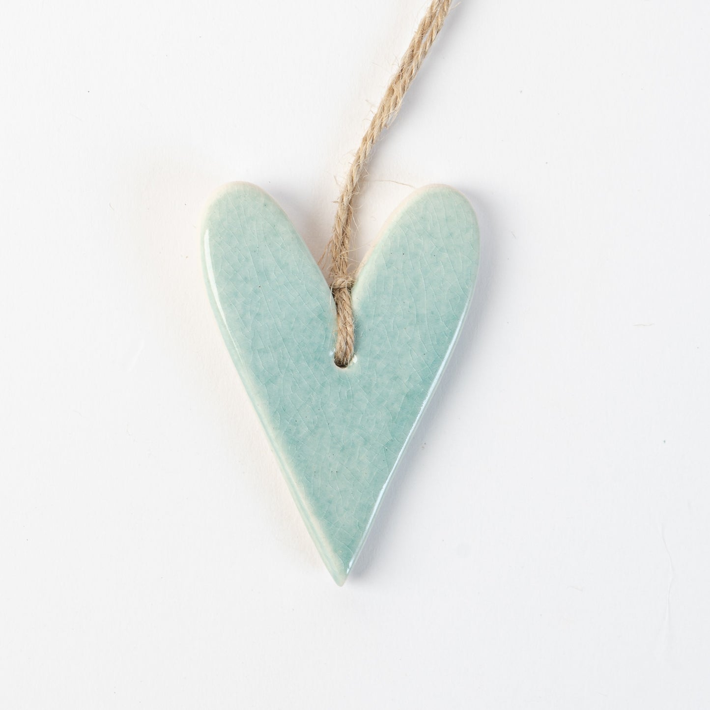 Arctic Blue Heart-shaped ceramic ornament hanging on a rope against a white background