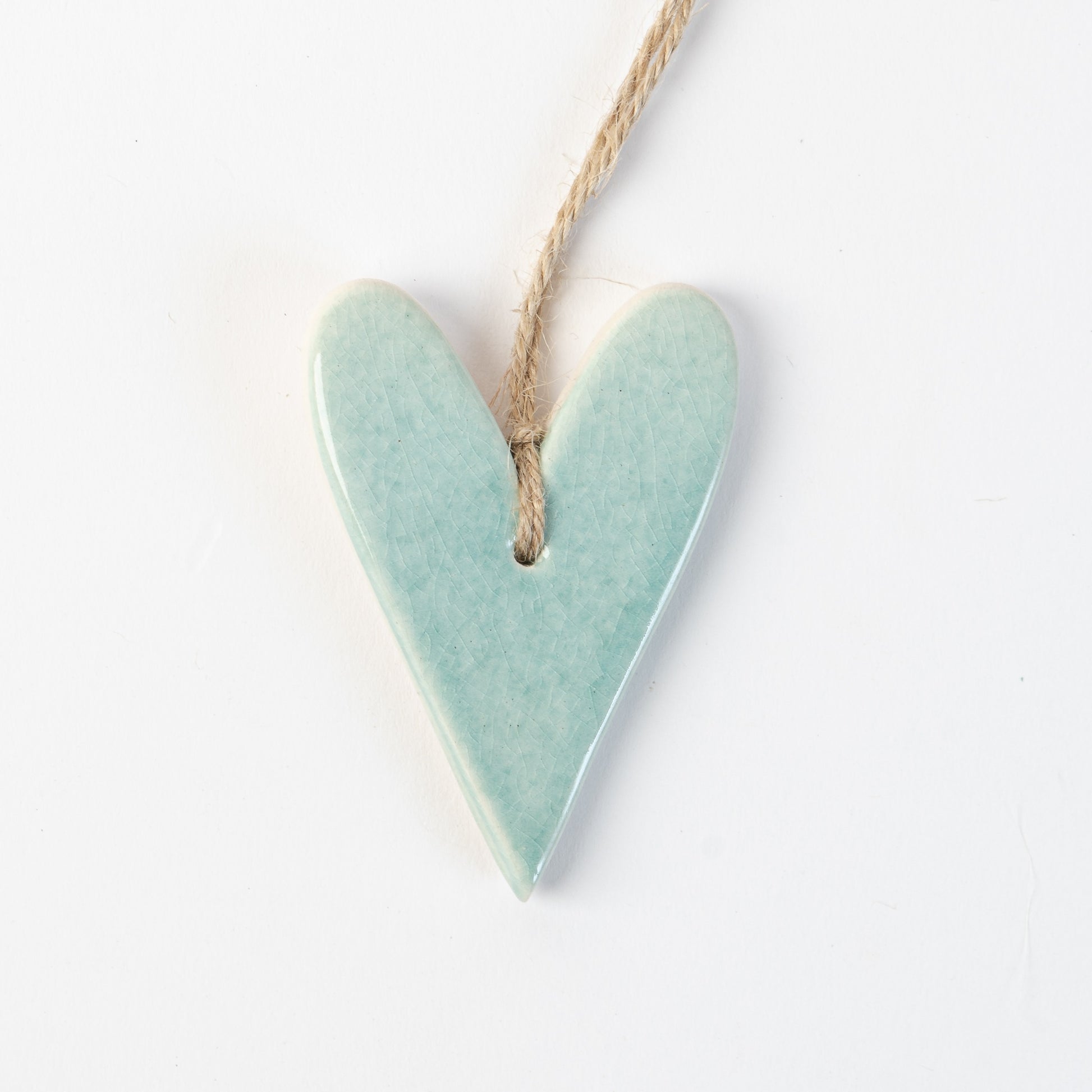 Arctic Blue Heart-shaped ceramic ornament hanging on a rope against a white background