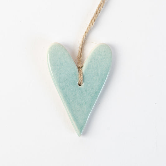 Arctic Blue Heart-shaped ceramic ornament hanging on a rope against a white background