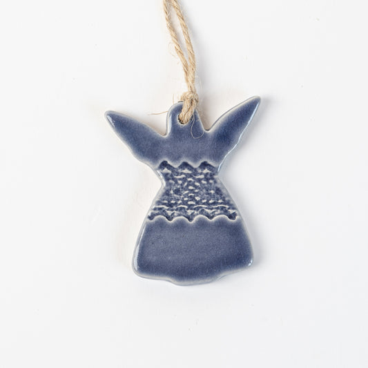 Ceramic angel in winter storm ornament hanging on a white background made by the wirksworth pottery company