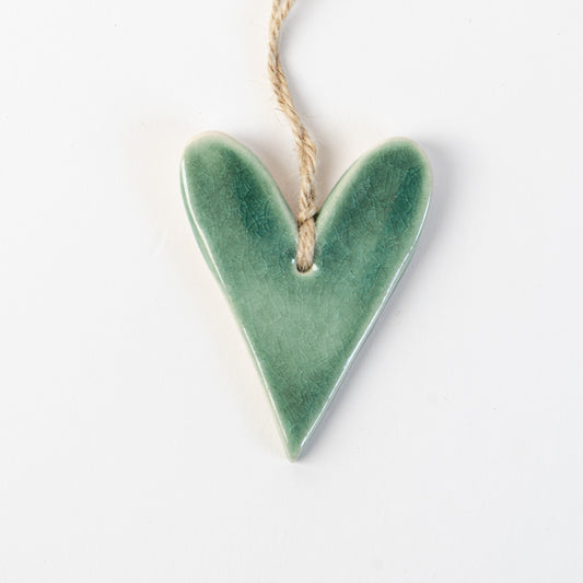 Fir Green Heart-shaped ceramic ornament hanging on a rope against a white background