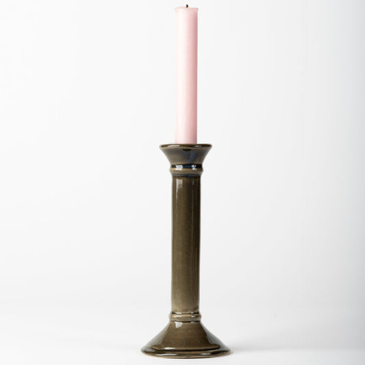 Decorative candle holder with a pink candle on a white background