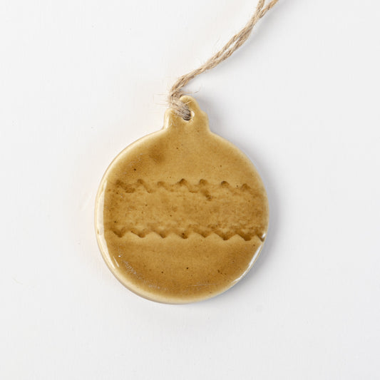 Golden yellow textured ceramic bauble ornament hanging on a white background made by the wirksworth pottery company