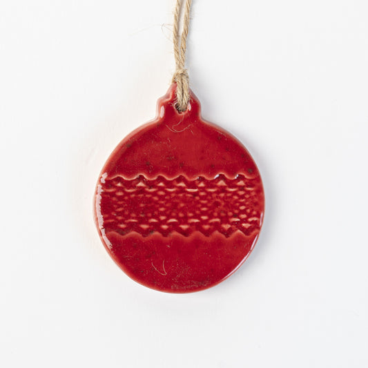 Red textured ceramic bauble ornament hanging on a white background made by the wirksworth pottery company